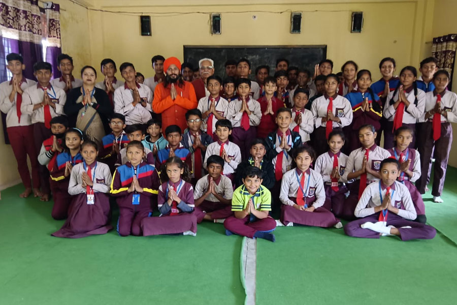 students in class room with namaskar pose